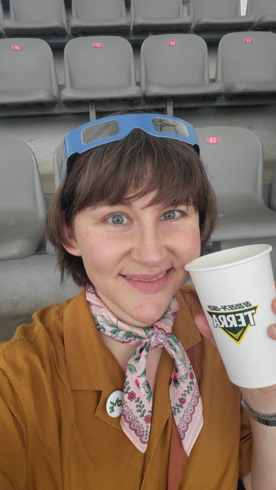 Selfie på blupparen emaihall med en öl i handen. Hon ler och ser kär ut.