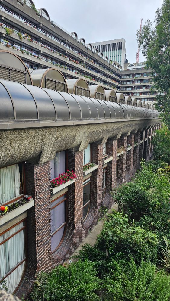 A large apartment block with large oval windows adorned with flower boxes.