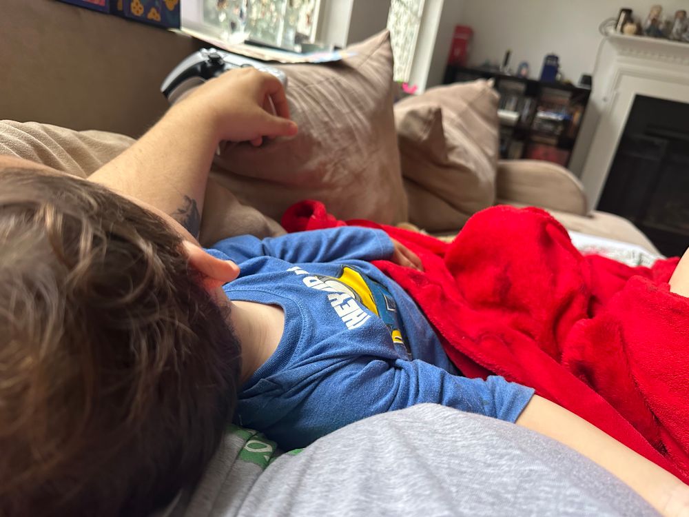 A dark haired baby (mine) asleep on someone's chest (also mine)