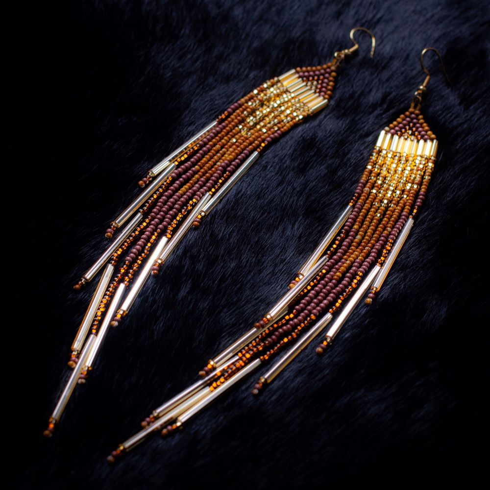brown fringe earrings either gold ends on black rabbit fur backdrop 