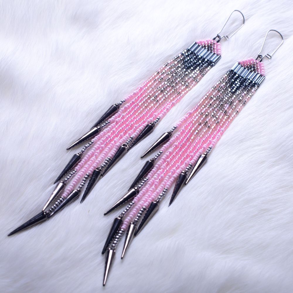 Pink and silver beaded fringe earrings with gunmetal spikes at the tips. On a white fur backdrop.