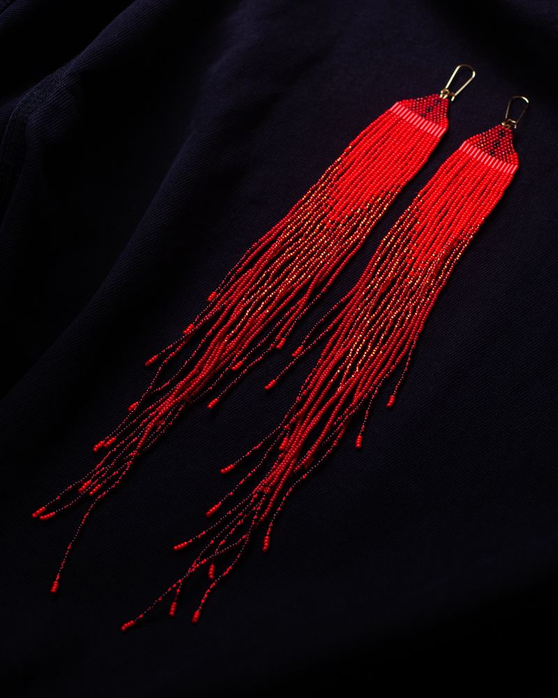 Extra large red beaded fringe earrings. From bright red to dark red ombré. On a black background 