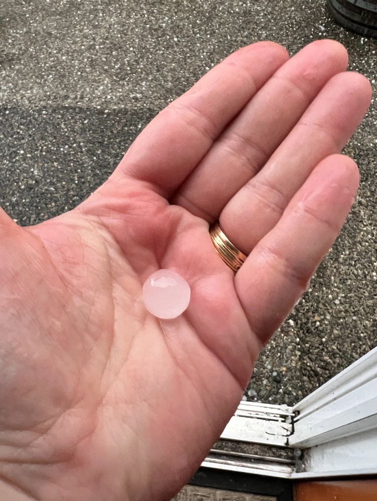 A perfectly round hailstone, approx half an inch in diameter, in the palm of my hand.