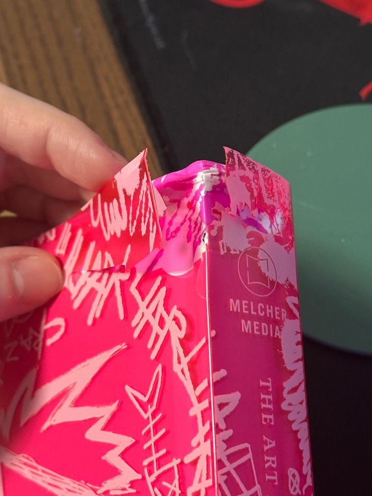 The Artbook with a heavily damaged corner