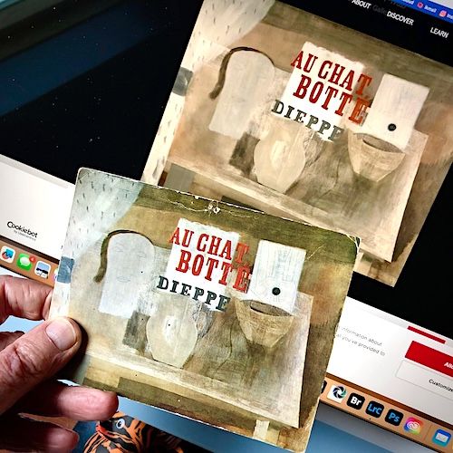 My hand holding a postcard of an artwork by Ben Nicholson titled "Au Chat Botté" in front of a computer screen with the same artwork on the screen.