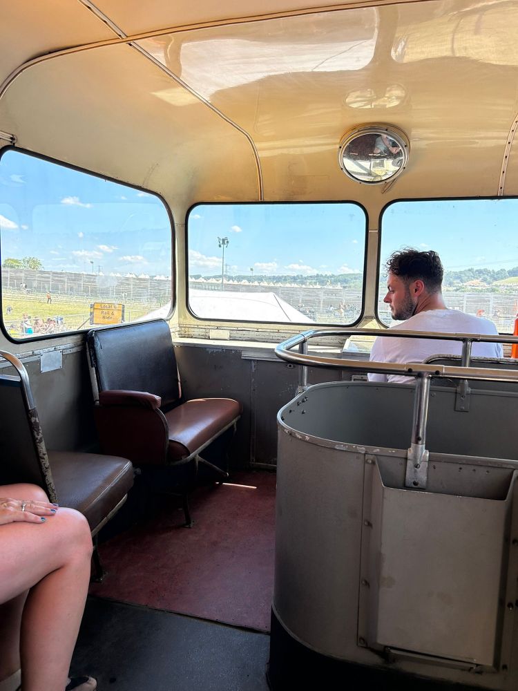 The front upstairs of a double decker bus. Instead of two rows of two seats facing forwards, it has one forward and one sideways. The next two rows have a single seat on one side facing forwards and the stairs on the other. It’s really odd