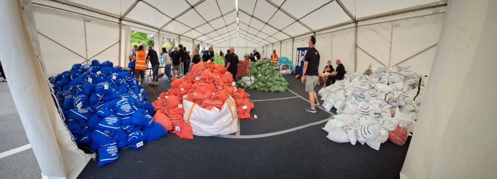 Interior of a large marquee with large piles of coloured cloth bags