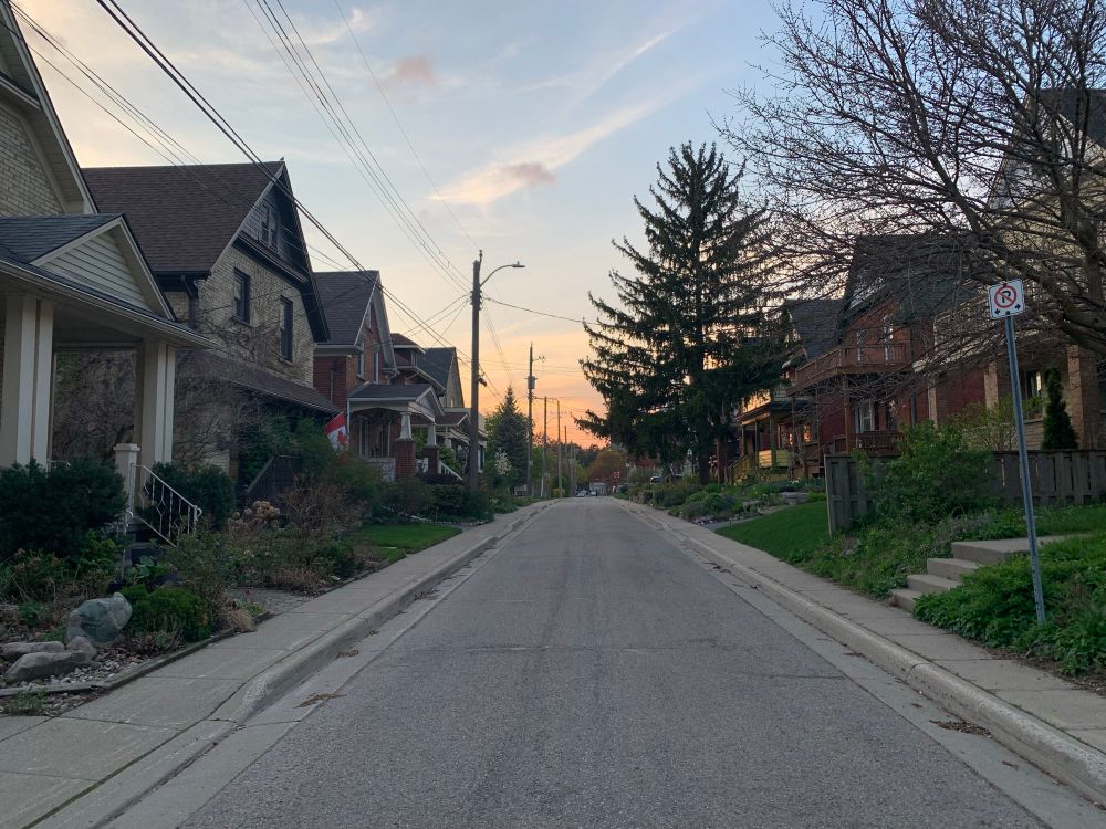 Image of a one way street lined with houses on both sides. There is no traffic on the street and the houses have minimal frontage making the street feel more enclosed and cozy.