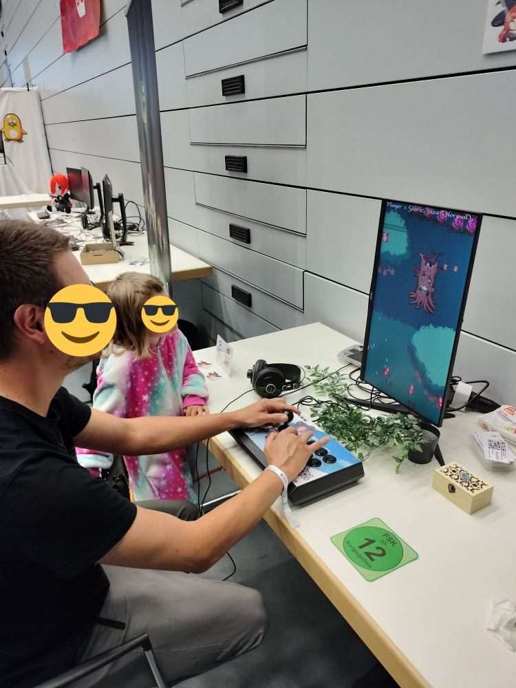 A father plays Warding Witches, his child spectating.