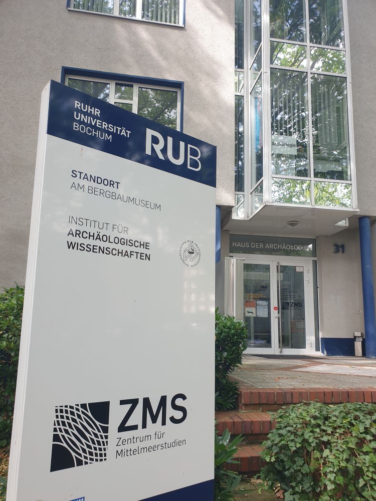 Das Gebäude, in dem die Archäologie der RUB sitzt, von außen fotografiert: es steht ein Schild davor, wo Archäologie draufsteht
