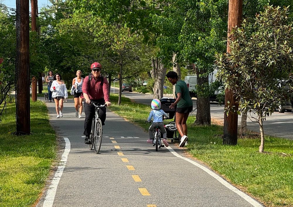 RI Av trolley trail with people walking, biking, pushing at stroller. 