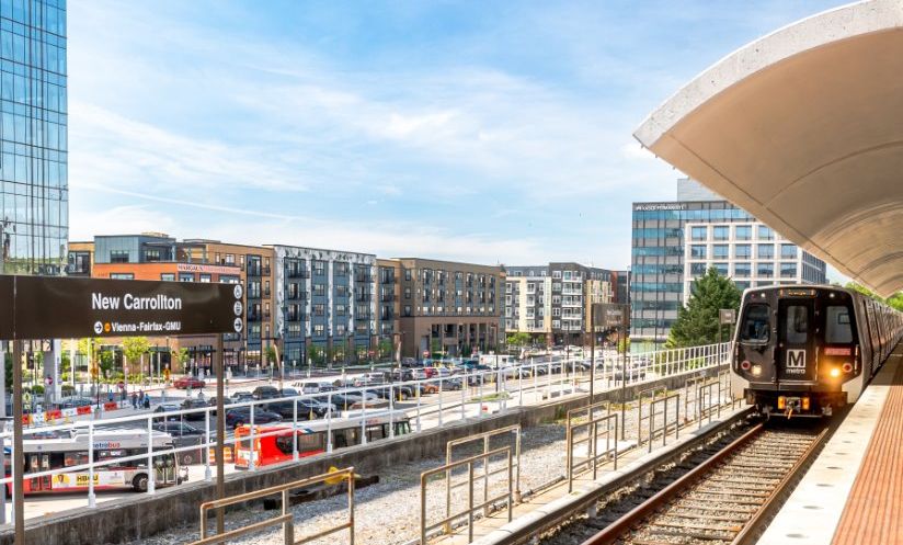 New Carrollton Metro station - Metro train arriving at platform, new buildings in background. Photo credit: WMATA