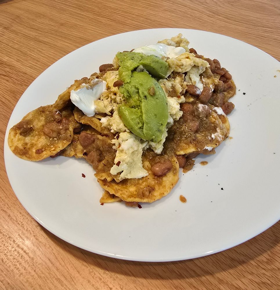 Some sad looking chilaquiles made by a white boy with Calidad tortilla chips, Herdez salsa verde, cup'o'guac, sour cream not queso fresco, and the only things made from scratch pinto beans and scrambled eggs. 