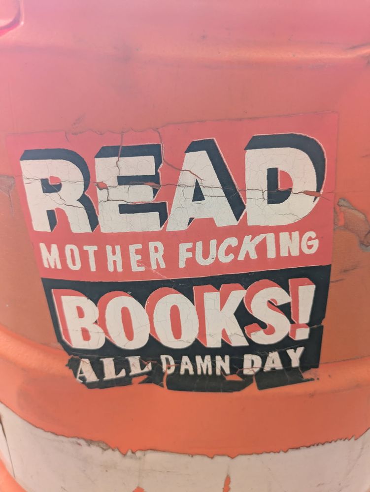 Sticker says "Read motherfucking books! All damn day."