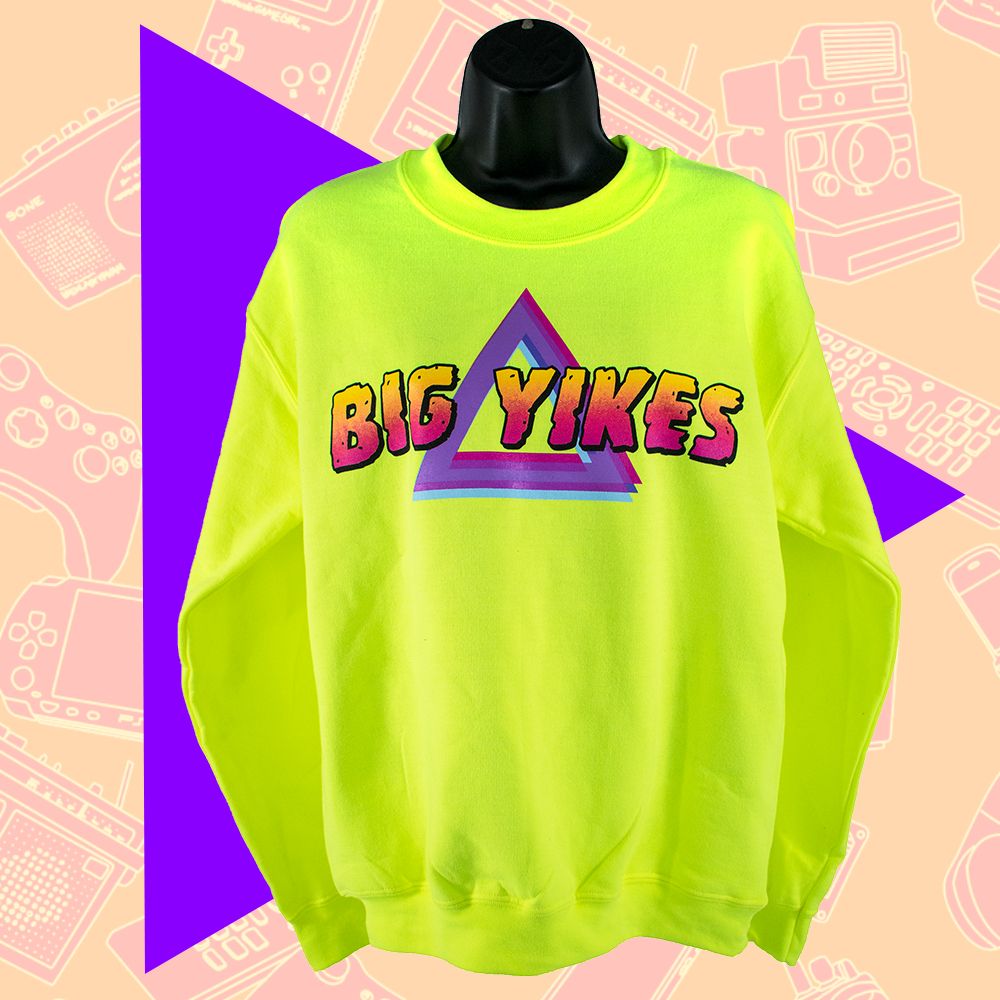 photo of a bright neon long-sleeve sweater with a graphic on the chest saying "BIG YIKES" in a large yellow and pink font over layered multicolored triangles.