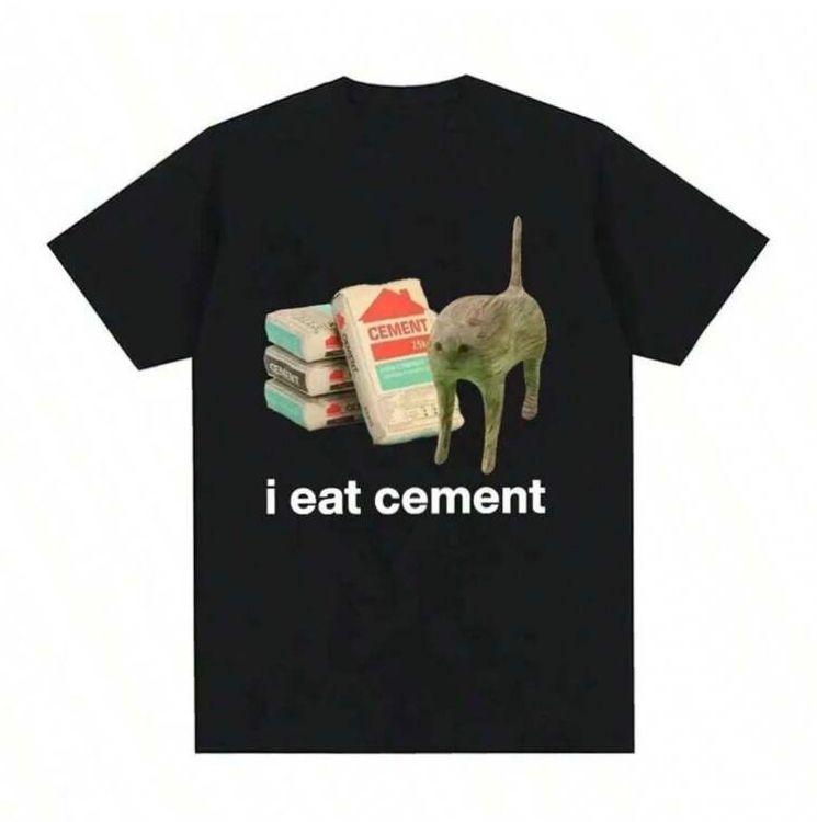 Picture of a black T-shirt featuring a picture of cement bags with a distorted cat standing in front of them. Below the picture is white text that says “i eat cement”
