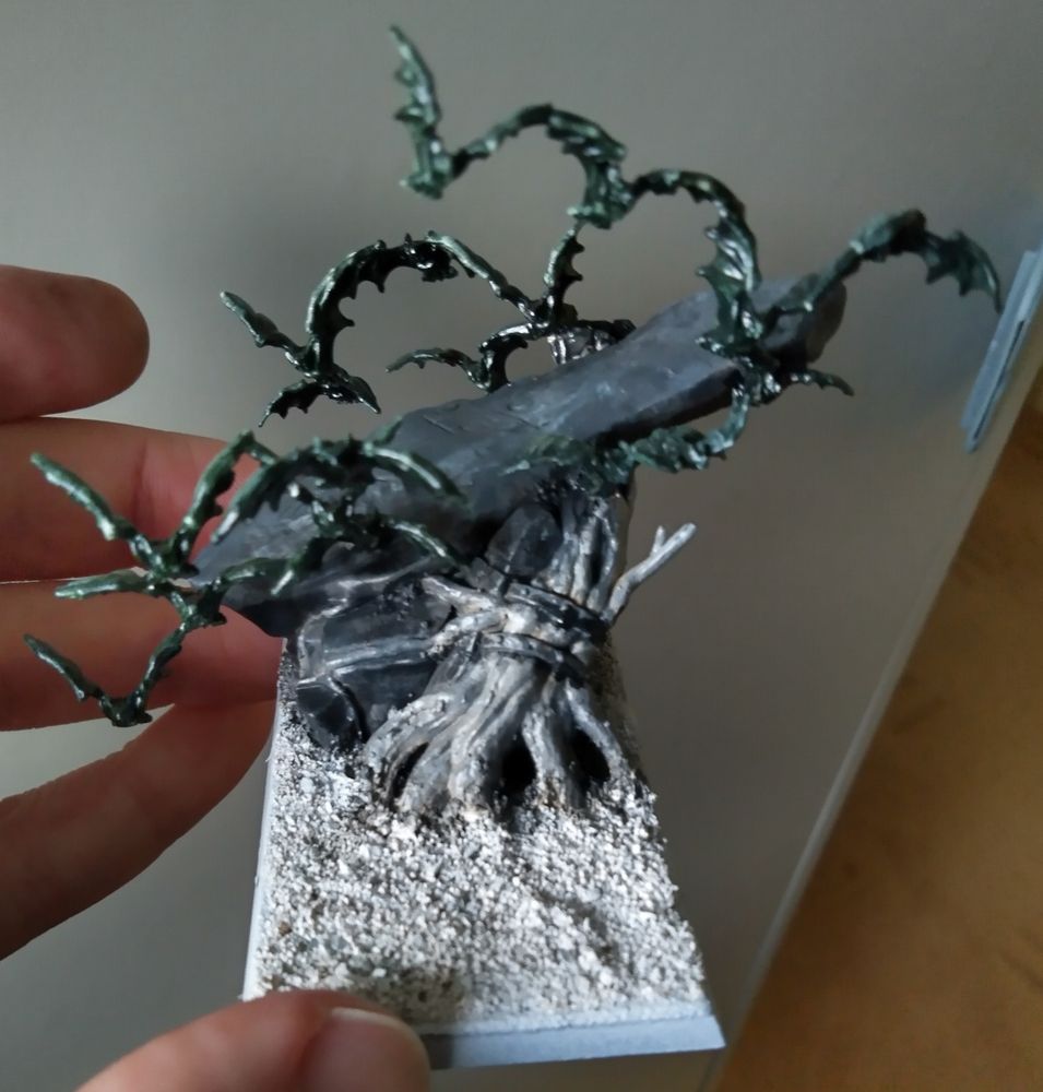 Scenic base of a large rock leaning against a tree stump, with a swarm of bats flying around it.