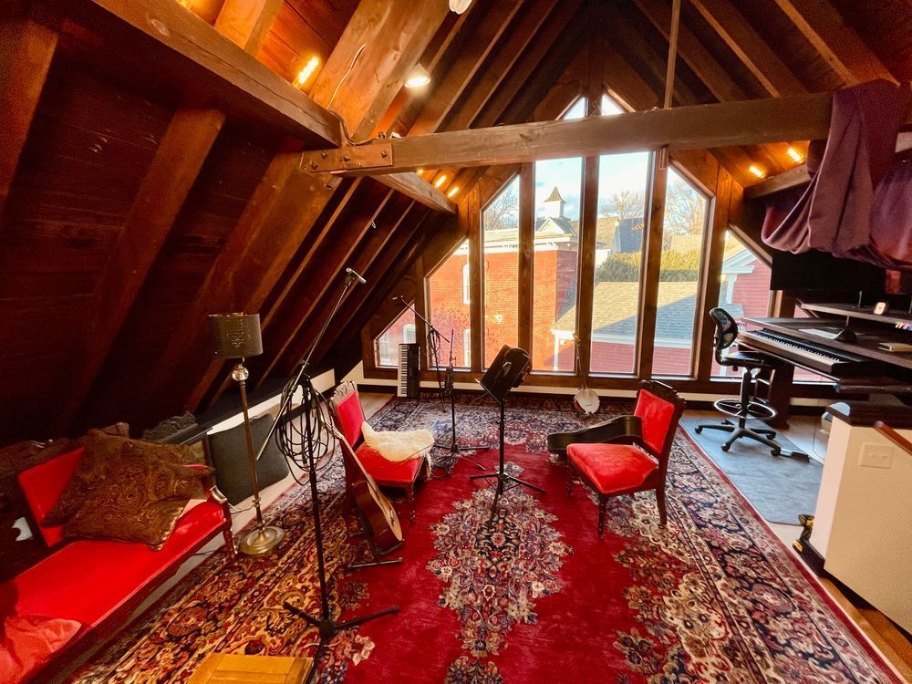 Ornate furniture and, acoustic instruments, and recording equipment in the loft space of the blue dot sessions production music recording studio in western mass