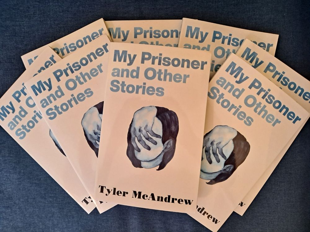 Several copies of my book, My Prisoner and Other Stories, arranged in a fanned-out pile on a blue background
