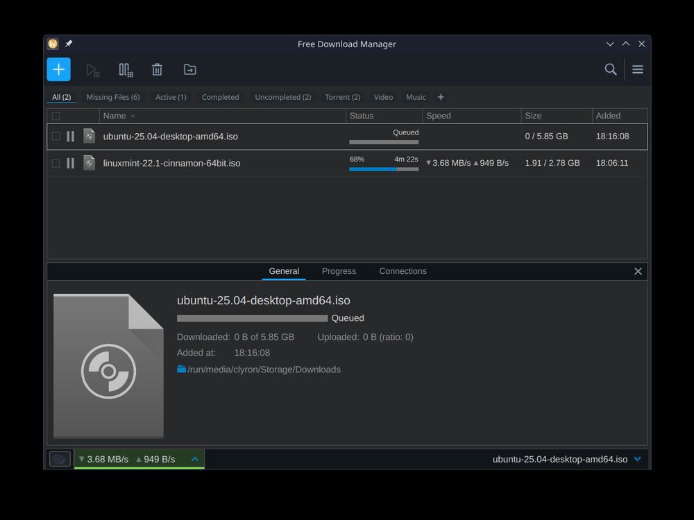 A Free Download Manager window, downloading ISOs of Ubuntu 25.04 and Linux Mint 22.1 Cinnamon