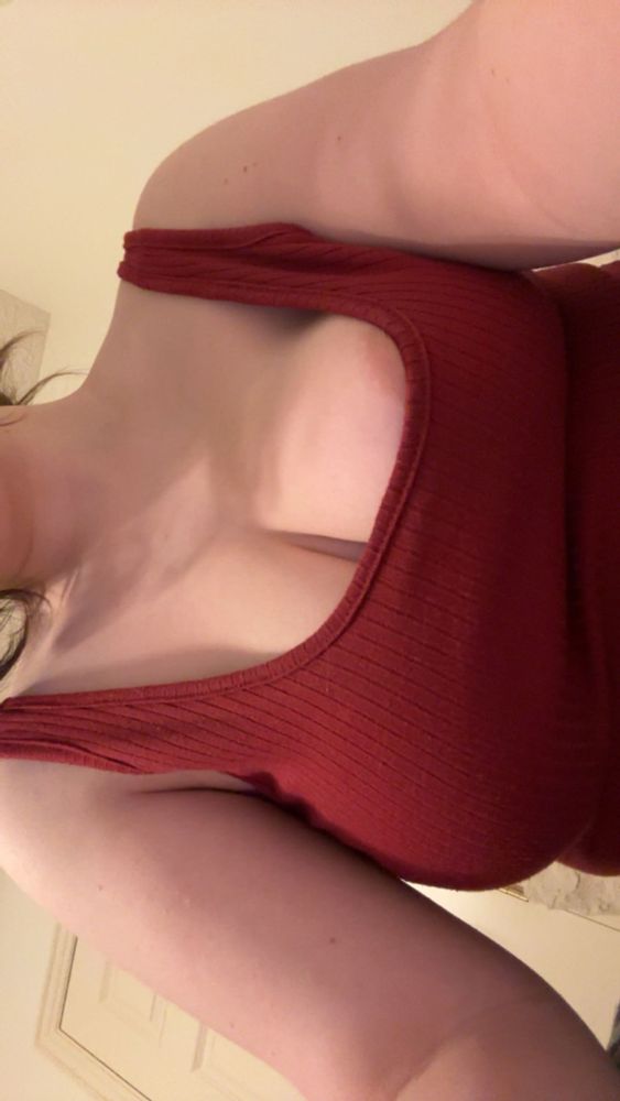 photo of rain with a red tank top. his cleavage is showing, and part of his left nipple is peaking out over his shirt