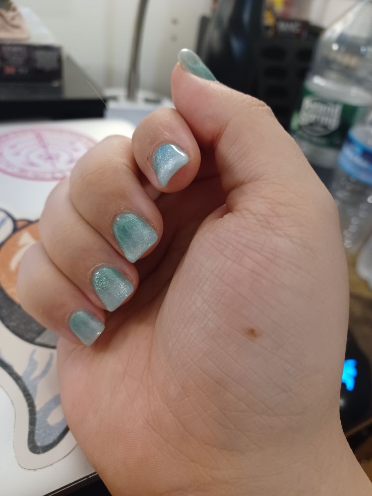 Em's nails, which are a green to white ombre with sparkly cats eye over it, making it look like shimmering mermaid scales