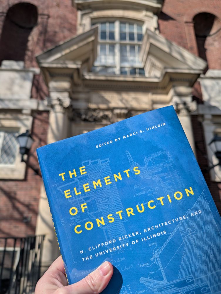 Photograph of a book cover for The Elements of Construction: N. Clifford Ricker, Architecture, and the University of Illinois, shown in front of the main entrance to the Architecture Building and Ricker Library on the University of Illinois Urbana-Champaign campus