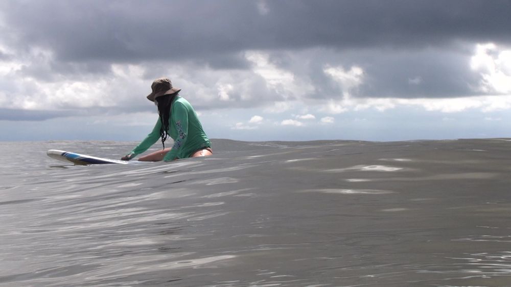 Sitting on my surf board, looking back at the ocean for waves.