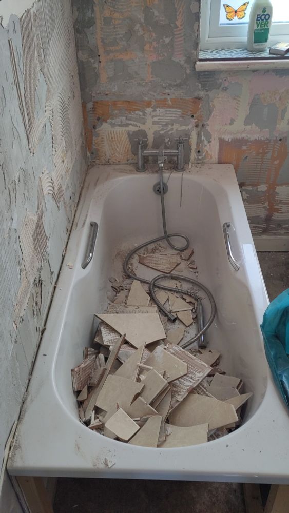 A bathtub filled with broken tiles