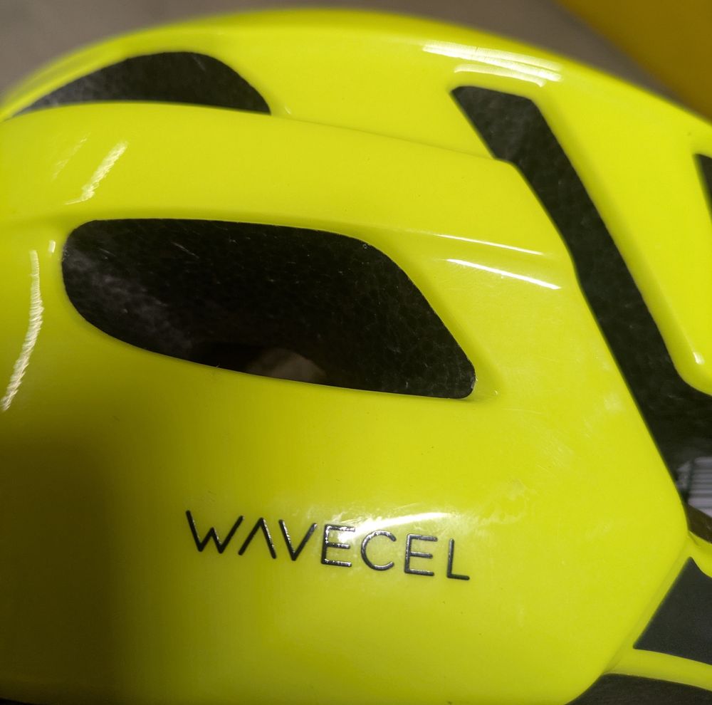 A yellow bike helmet featuring a the word logo "wavecel" in black letters 