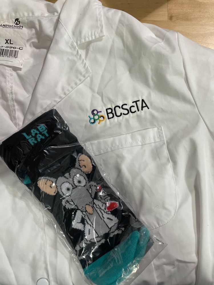 White lab coat with BCScTA logo and a pair of Lab Rat socks with a gray rat holding a flask with red fluid.