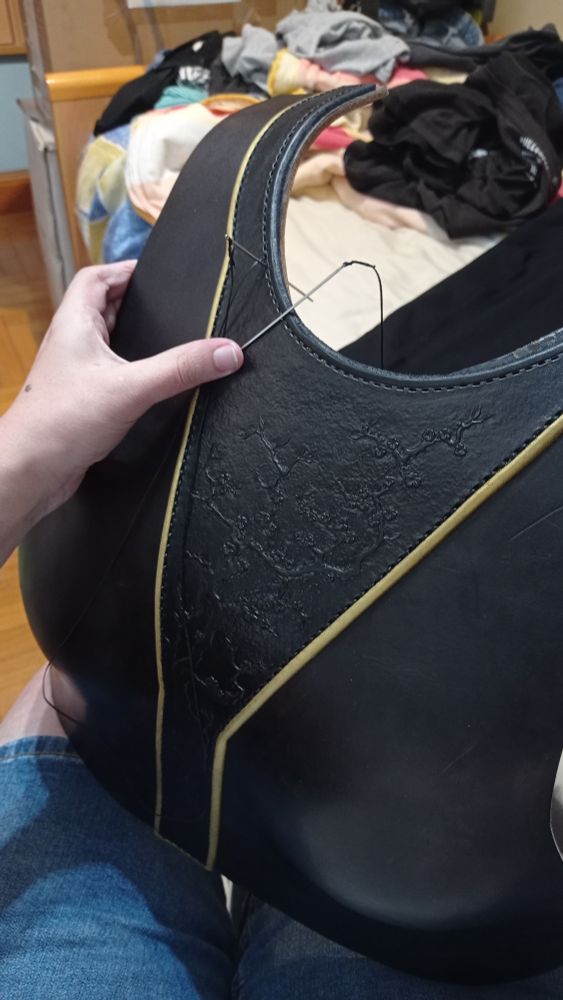 Pic of the chest almost stitched completely, only part of the neckline left, the stitching line side by side with the decorative border painted in golden and the thread almost invisible in comparative with it