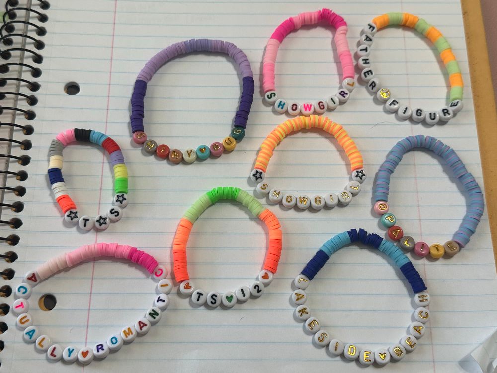 9 colorful friendship bracelets on an open notebook. 