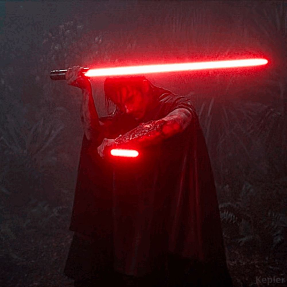 a man in a black cape is holding two red lightsabers in the dark