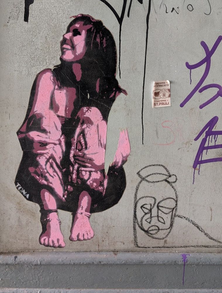 Eine sitzende junge Frau, die lächelnd nach links oben schaut.