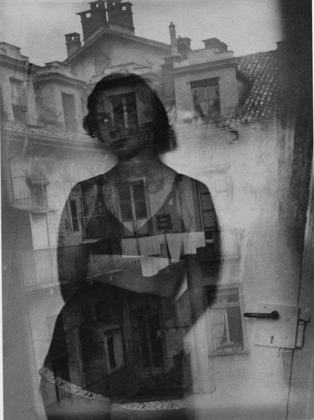 Schwarz-weiß Fotografie
Ein (Berliner) Hinterhof. Man sieht eine gespannte Wäscheleine zwischen 2 Fenstern.
Davor eine mit Unterwäsche bekleidete Frau.     