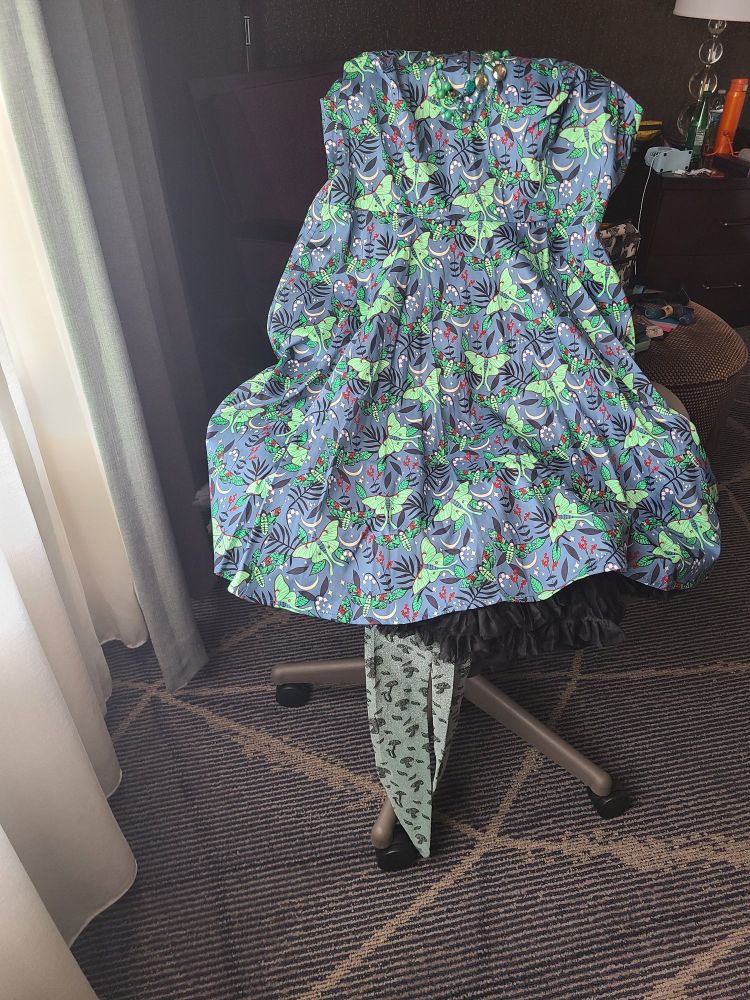 A skate blue swing dress covered in light green Luna moths, sparkly light green rights with mushrooms on them, and a seriously sparkly Swarovski necklace made by Vivian Shaw. 
