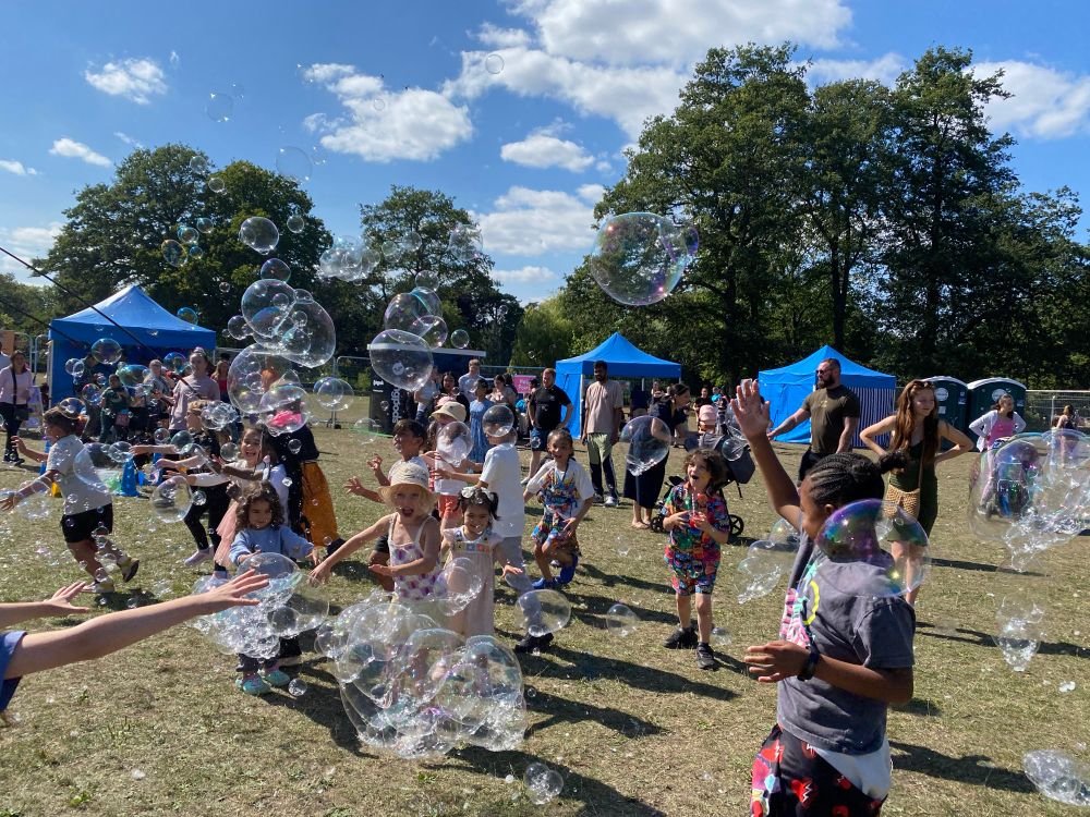 Children chasing bubbles in a festival field