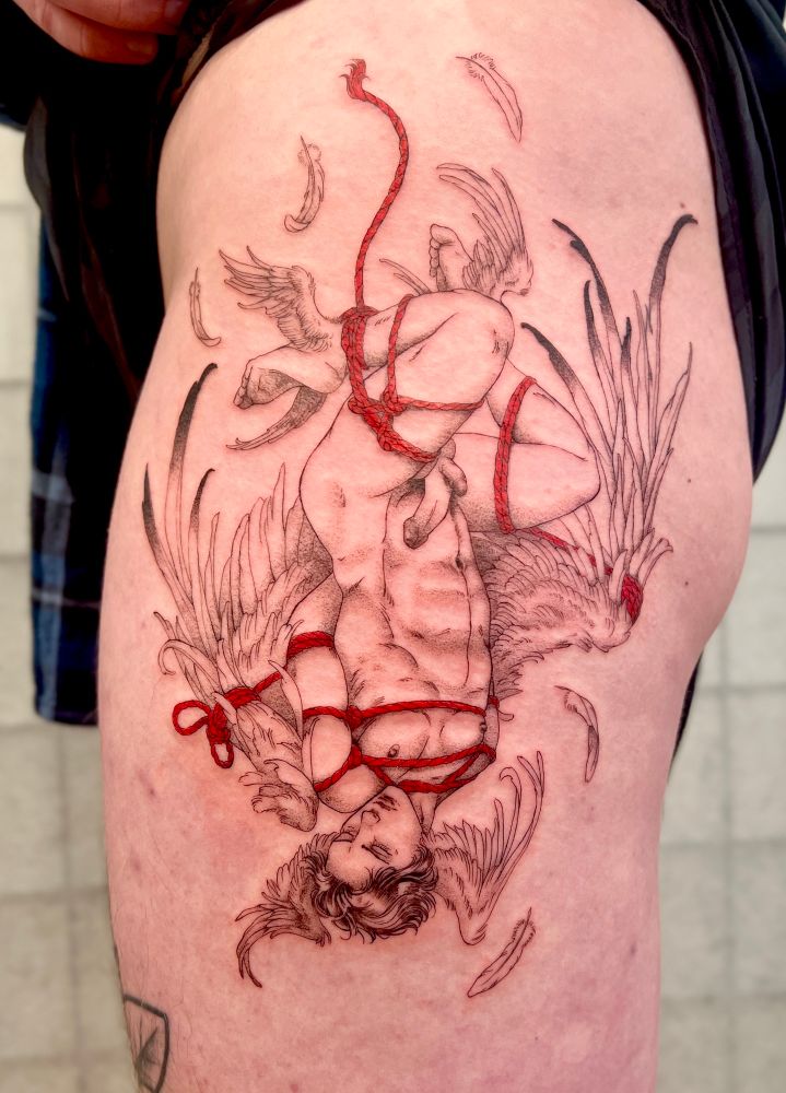 Tattoo of a trans masculine angel with six wings and two penises wrapped in red rope and hanging upside down.