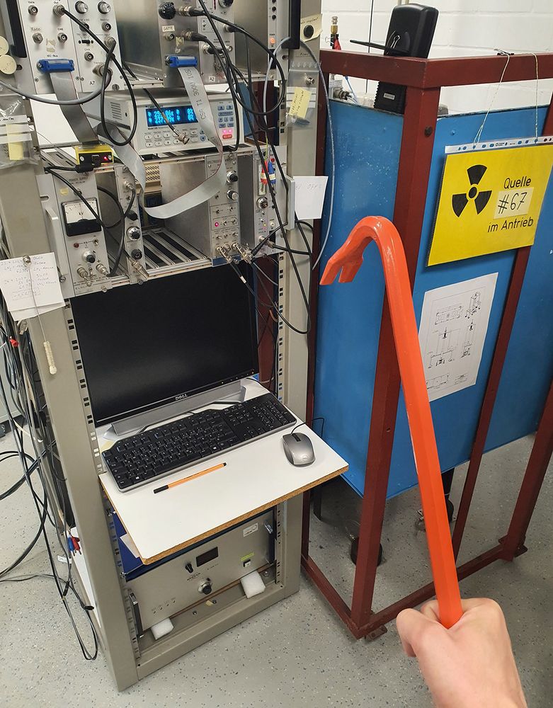 Photo of a hand holding a red crowbar while standing in front of scientific equipment, just like Dr. Gordon Freeman.