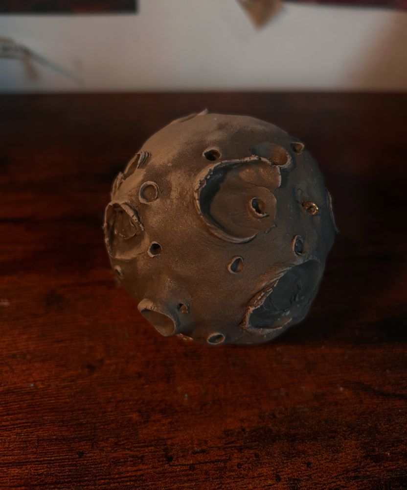 Lune sculptée avec des cratères, la pâte qui sèche forme des zones plus claires que d’autres 