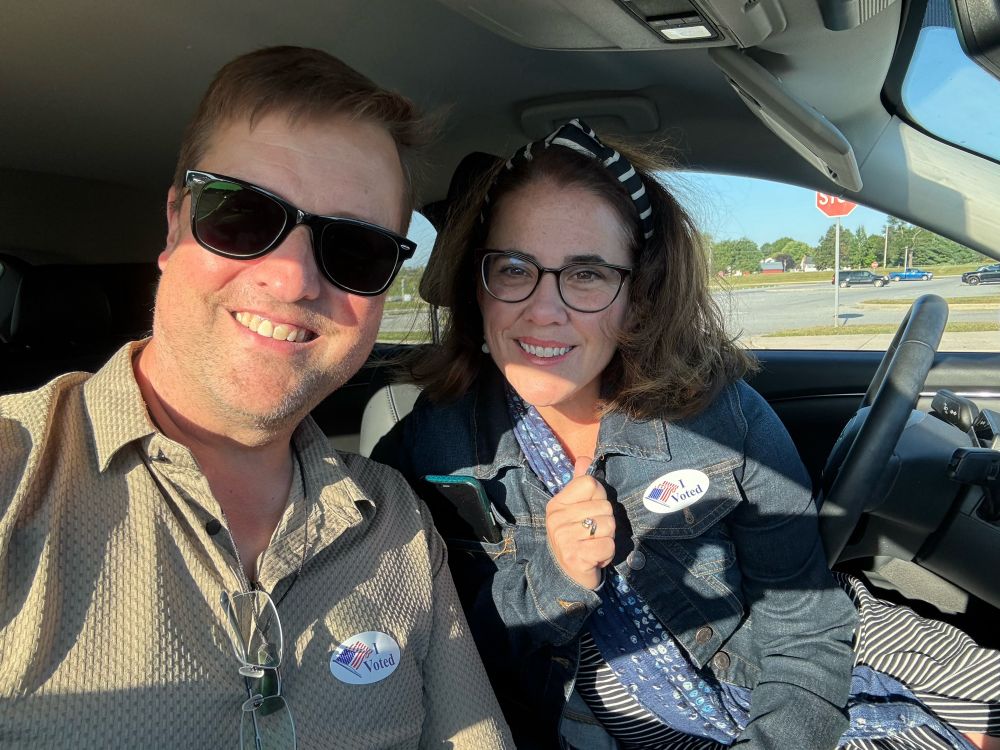 Two smiling people with I voted stickers