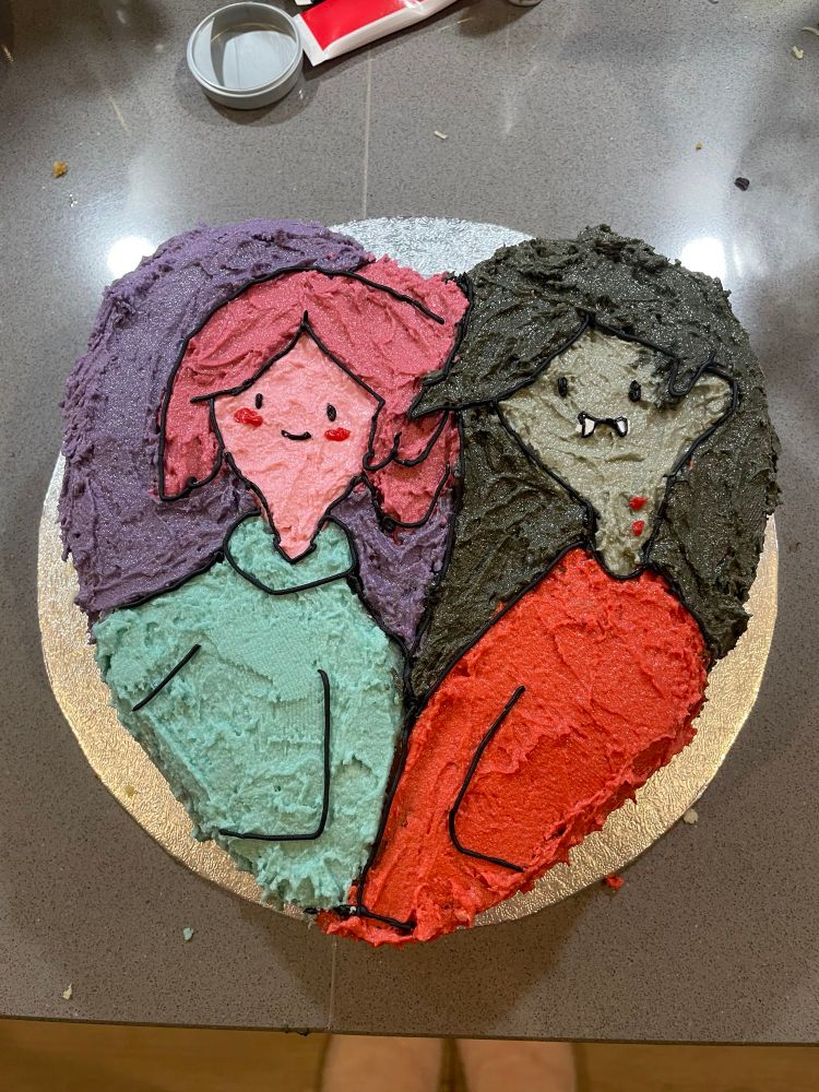 A heart shaped cake with buttercream frosting that looks like Princess Bubblegum and Marceline from Adventure Time