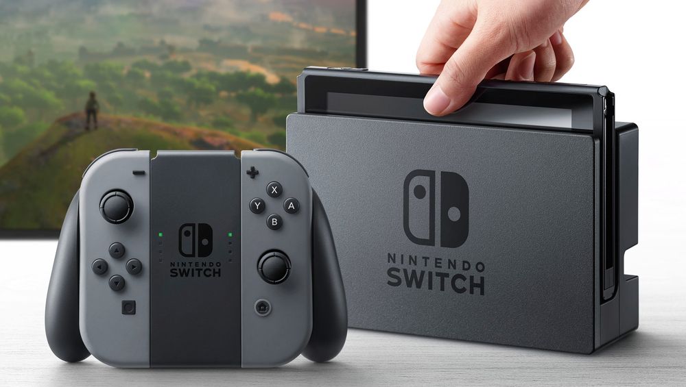 The Nintendo Switch inside of its dock, as well as its grey Joycon controllers inside the 'dog' handheld to make it better resemble a usable controller.