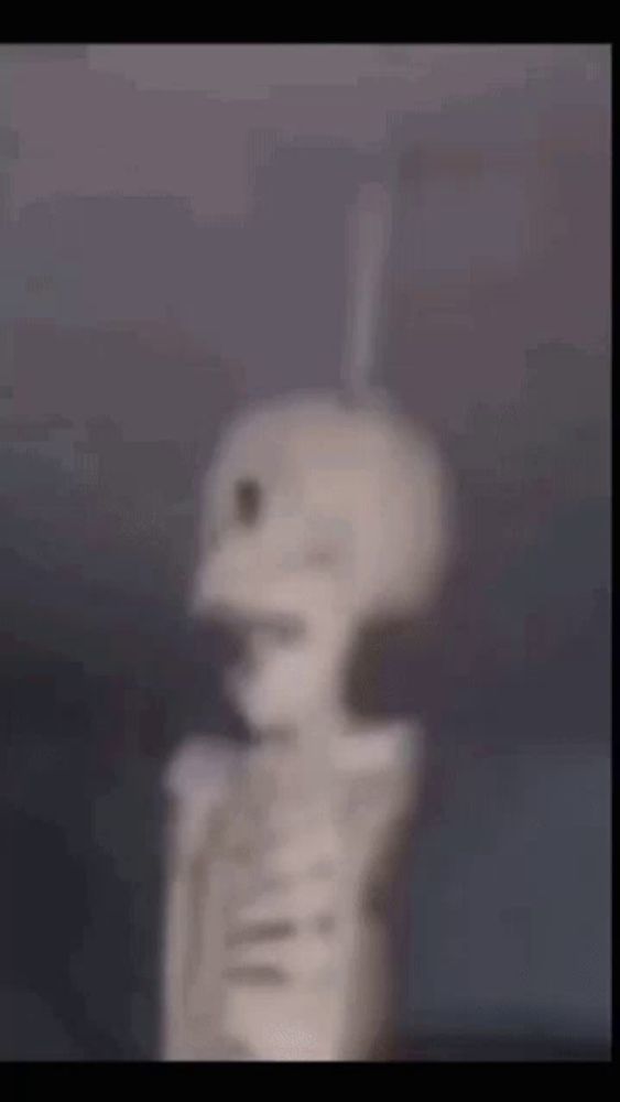 a blurry picture of a skeleton with a bat sticking out of its head .