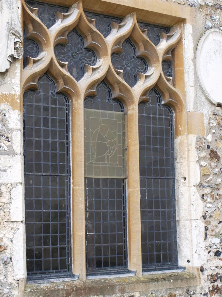 The William of Occam window from outside, showing how small the stained glass piece is within the window.