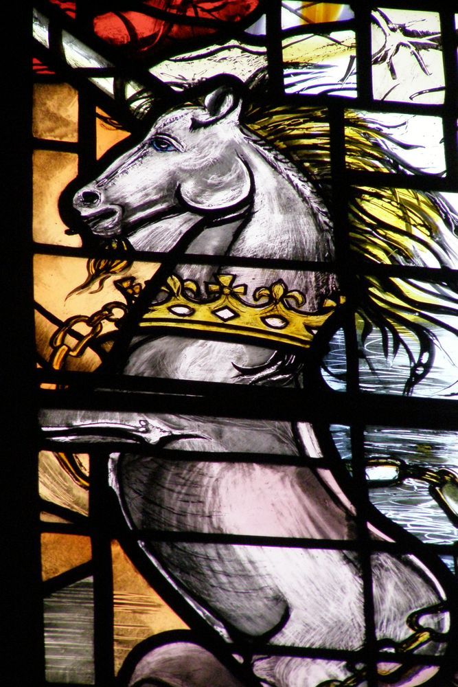 Close up of a unicorn with a crown collar in stained glass.