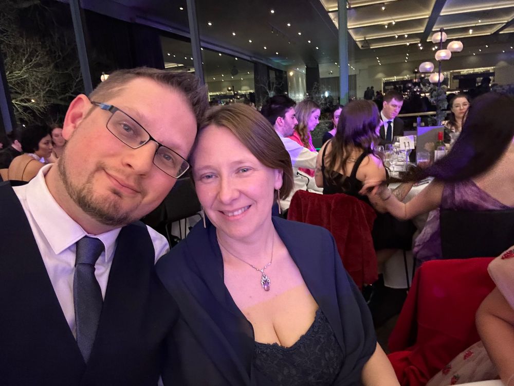 My wife and I seated a table in a wedding reception wearing more formal go-out clothing. 