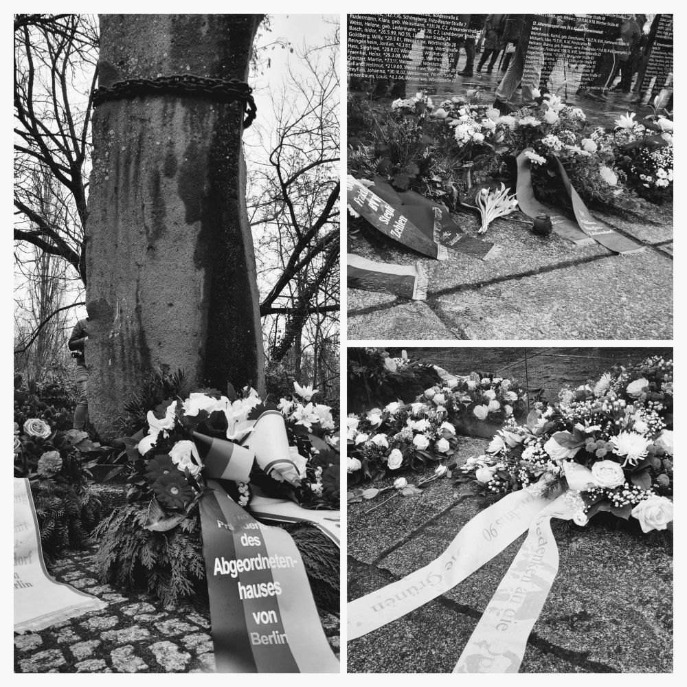 Gedenkkränze liegen unter der Säule der Gefangenen und der Spiegelwand
