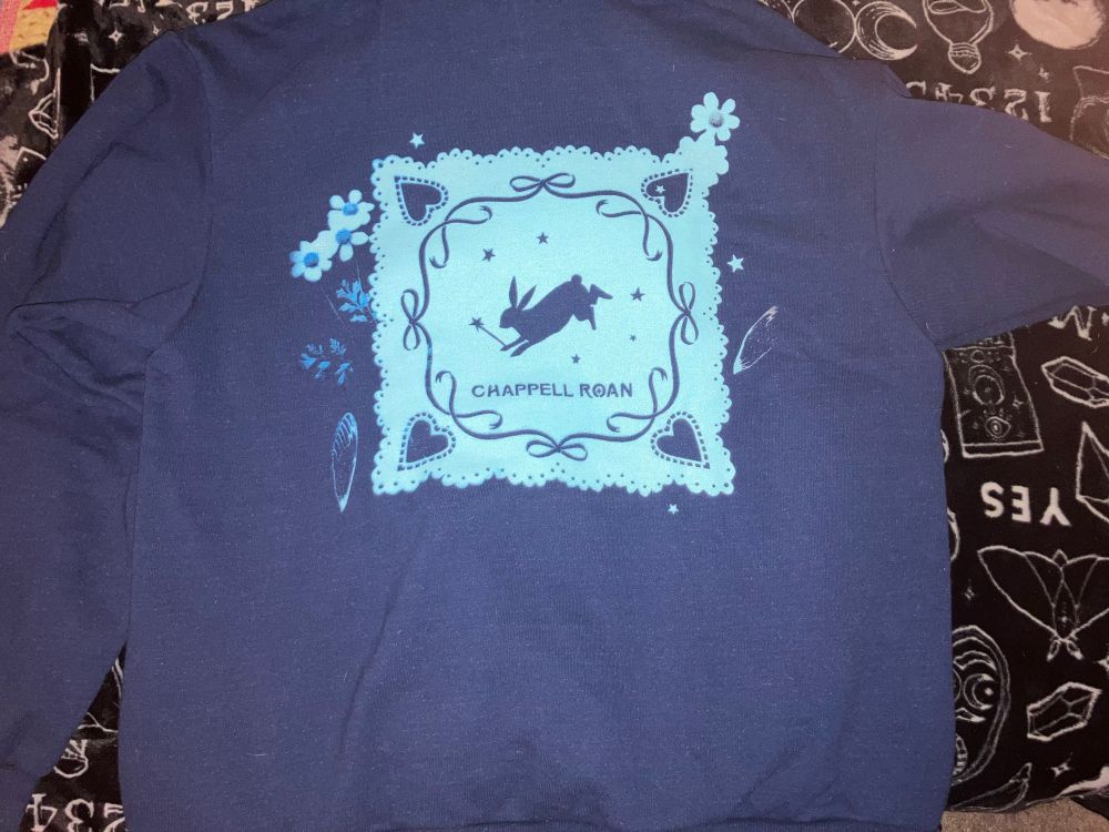 Back of jacket with Chappell Roan logo with rabbit holding a wand.